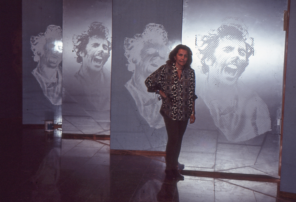 Ana María Mazzei junto a la instalación Ámbito. Serigrafía y esmalte sobre 14 puertas de madera revestida con fórmica aluminizada. 244 x 122 cm c/u, exhibida en Natura, Museo de Arte Contemporáneo de Caracas Sofía Ímber, 1993.